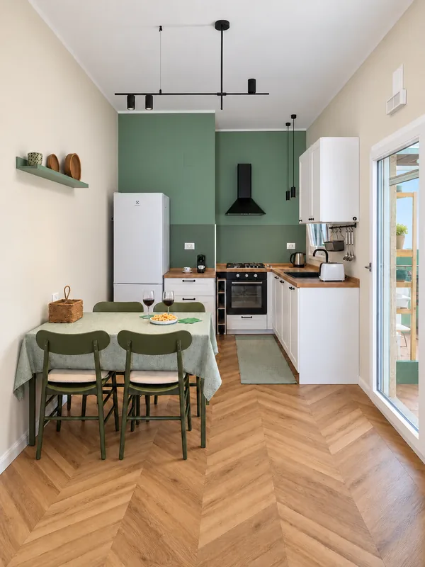 Bright kitchen with sage green walls and a dining table for six, BDS House Brindisi